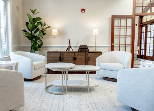 a living room with white chairs and a coffee table at Broadlands Apartments in Ashburn